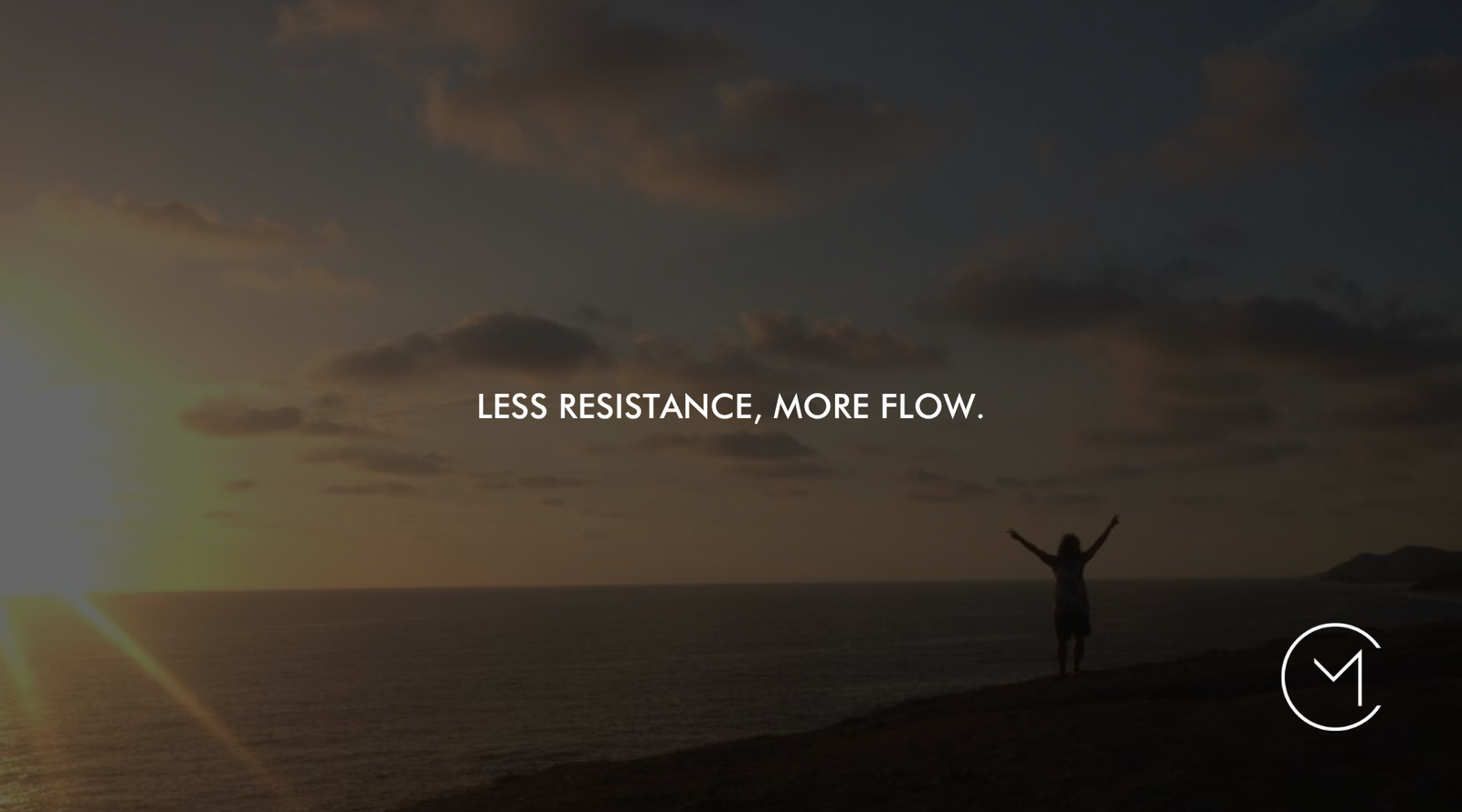 A person stands with arms raised beside the ocean at sunset, illustrating alignment, reduced resistance and greater flow in life.
