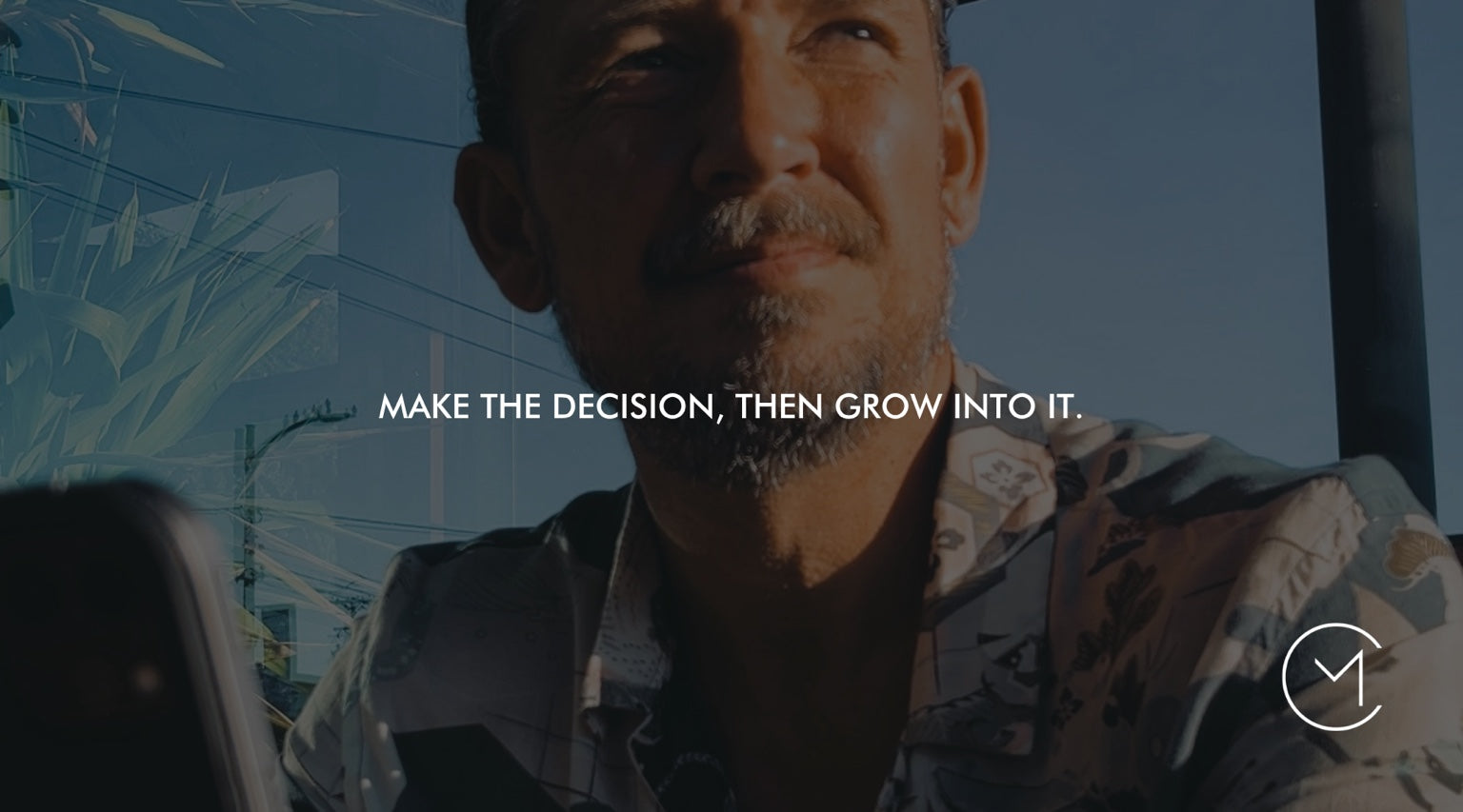 A man looks ahead while working on a device, illustrating decision-making, learning and adapting after a choice is made.