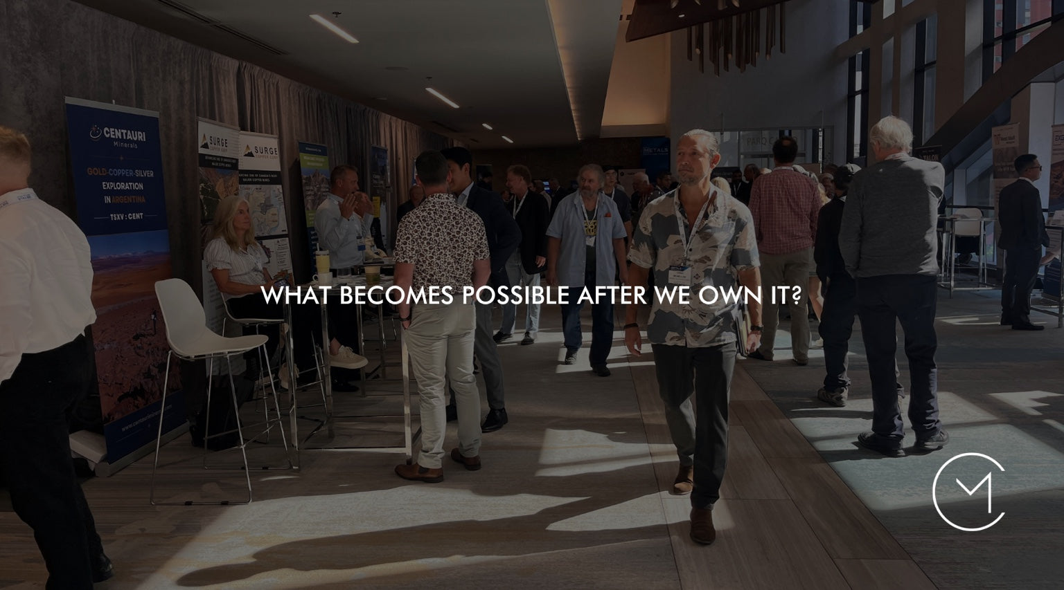 A man walks through a business conference, illustrating the strategic question of what becomes possible after an acquisition.