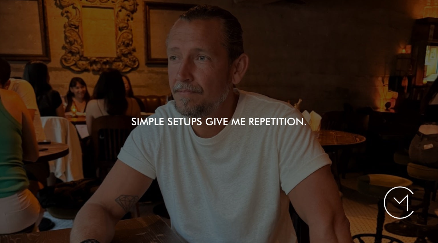 A man sits in a restaurant, illustrating the trading principle that simple setups create repetition and consistency.