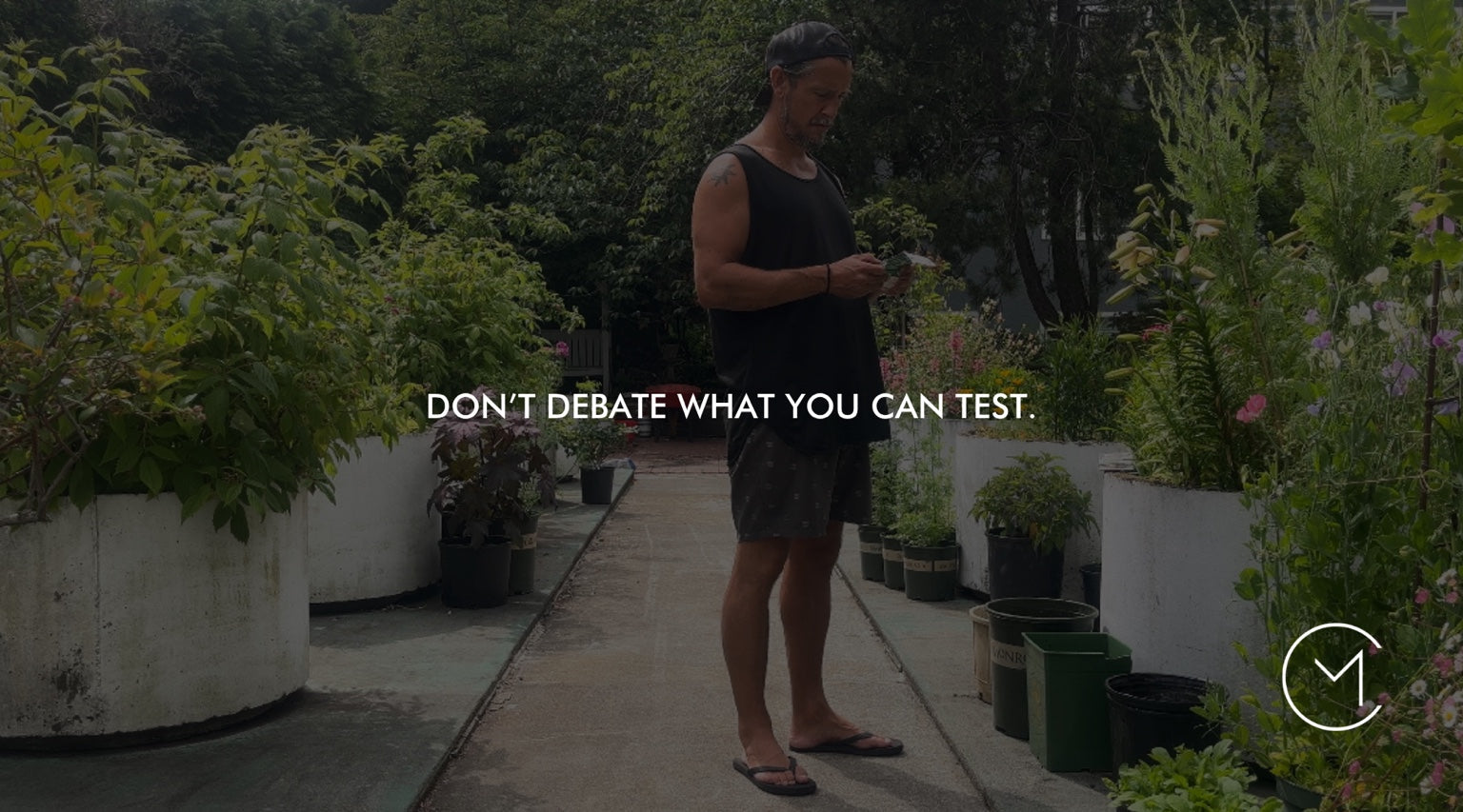 A man examines plants in a garden, illustrating the value of testing ideas through small experiments instead of relying on assumptions.