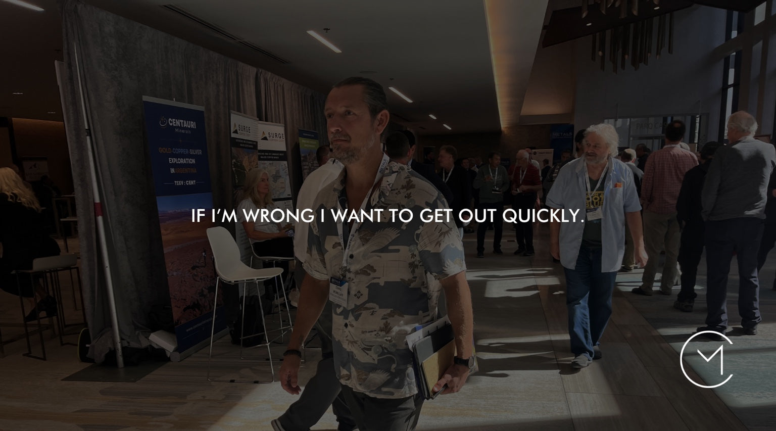 A man walks through a capital markets conference, illustrating the trading discipline of exiting quickly when a trade proves wrong.