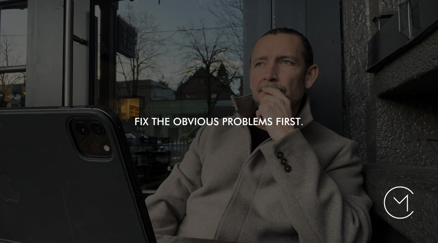 A man sits thoughtfully with a laptop, illustrating the process of identifying and fixing the most important problems in a company turnaround.