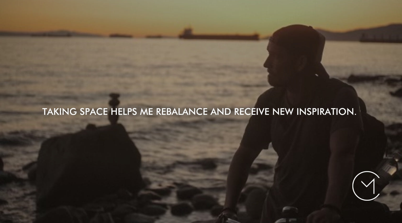 A man sits by the ocean at sunset, illustrating the value of creating space to think, rebalance and find new inspiration.
